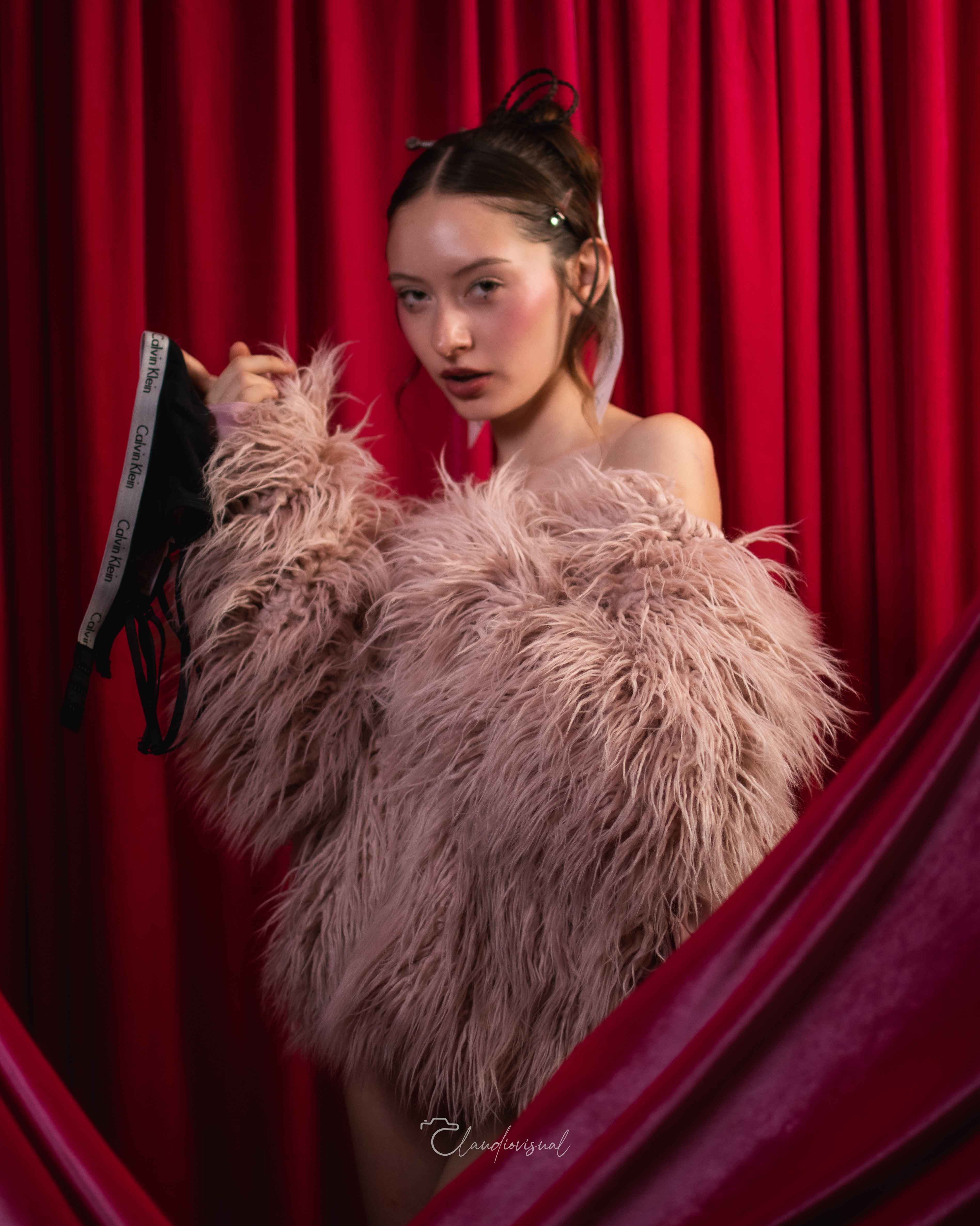 Soso Peralta — retrato editorial con cortina roja y boa rosa